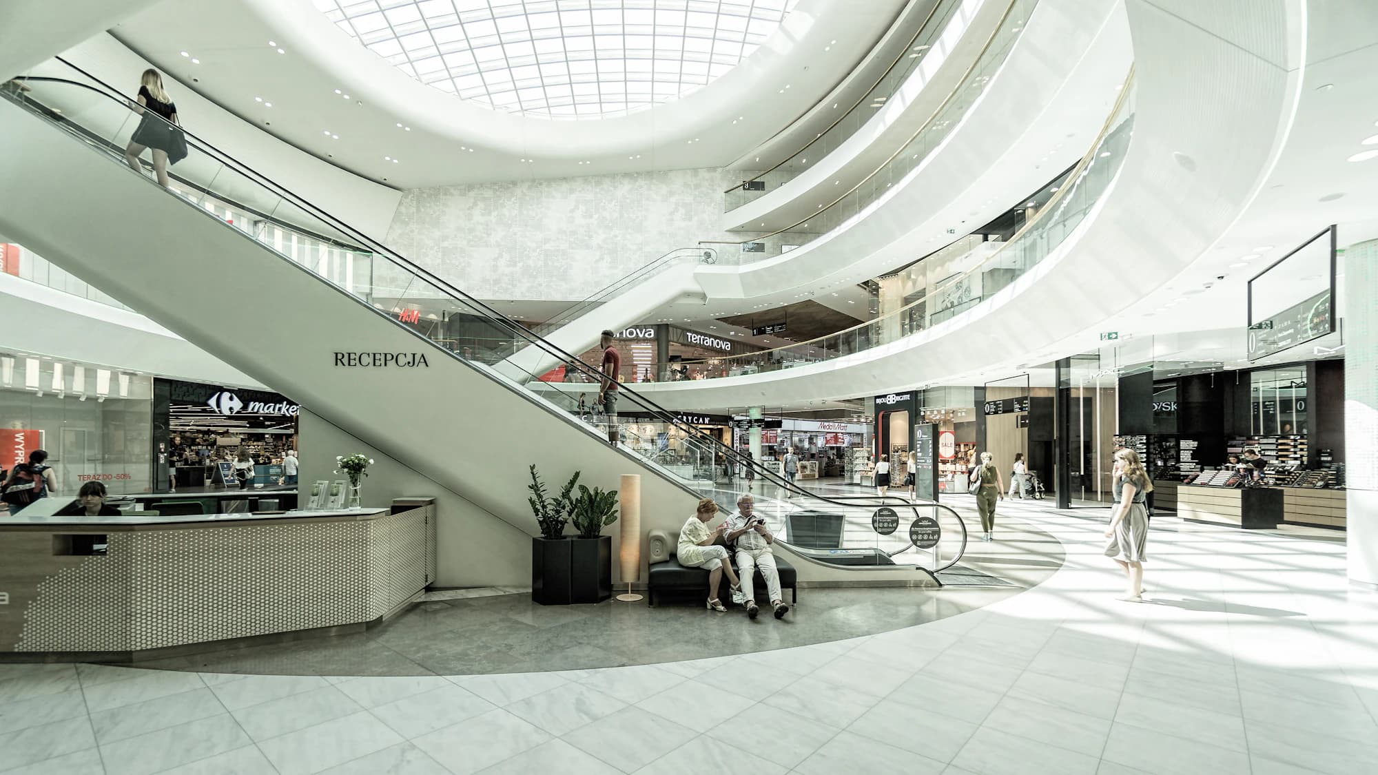 Gün ışığı alan modern bir alışveriş merkezi atriyumu